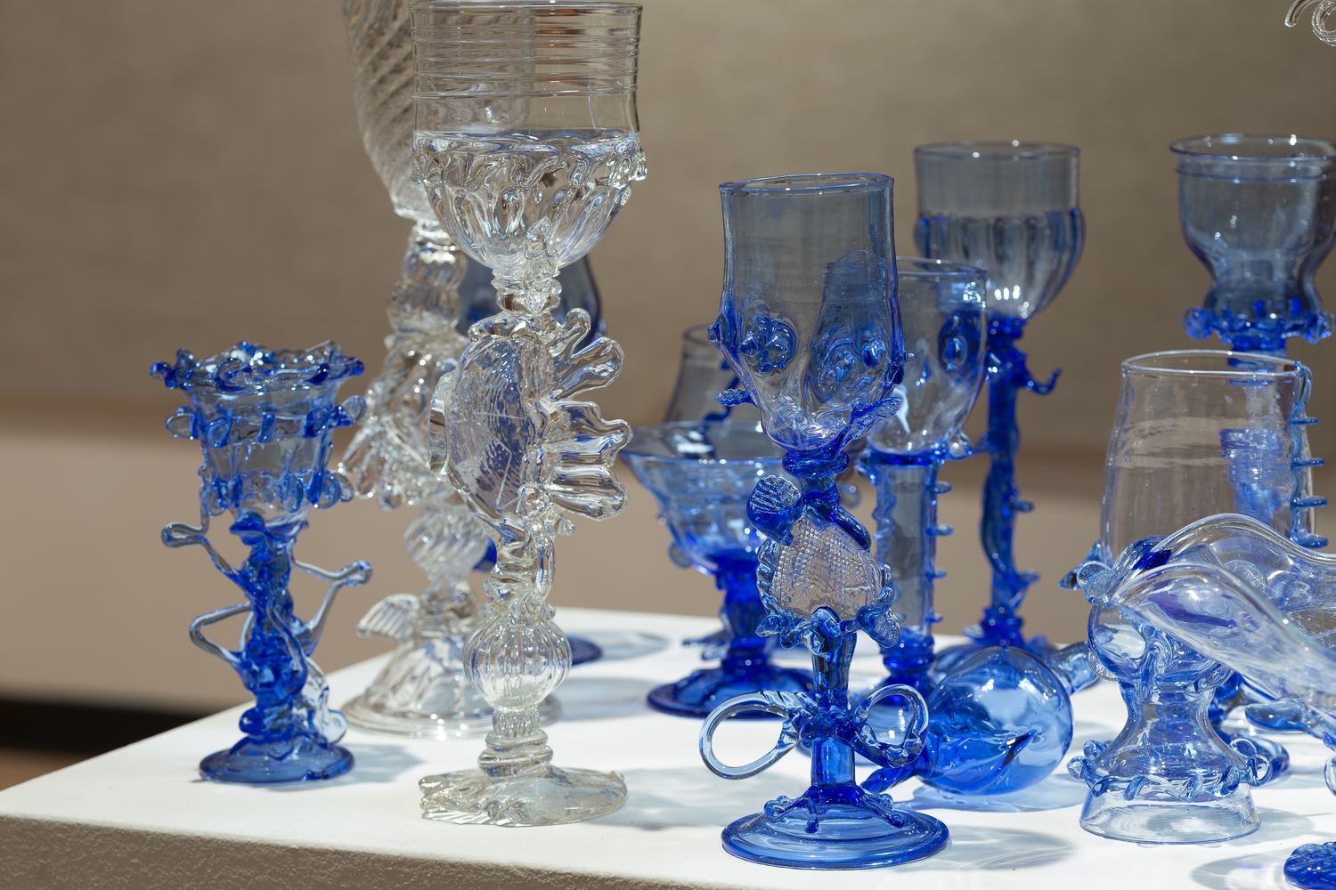 Blown cobalt glass: goblets, vessels and small forms on a lit plinth
