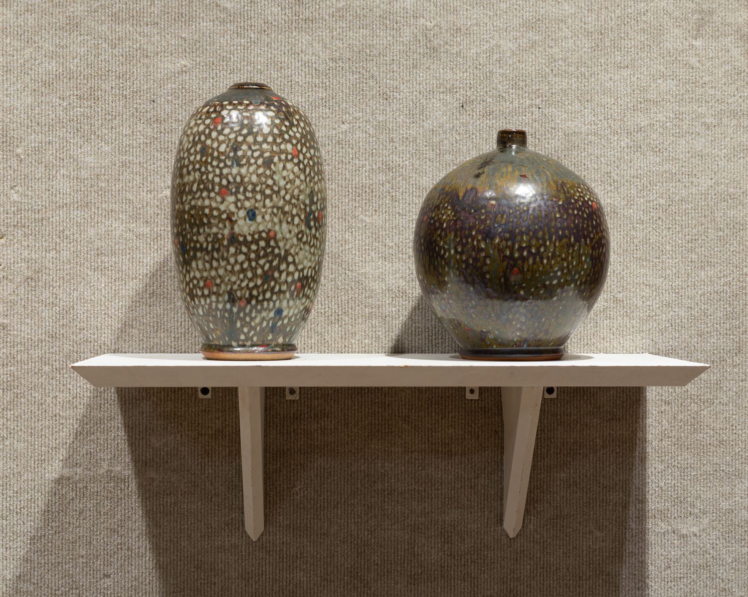 Keaton Wynn ceramics: two speckled vessels on a gallery shelf