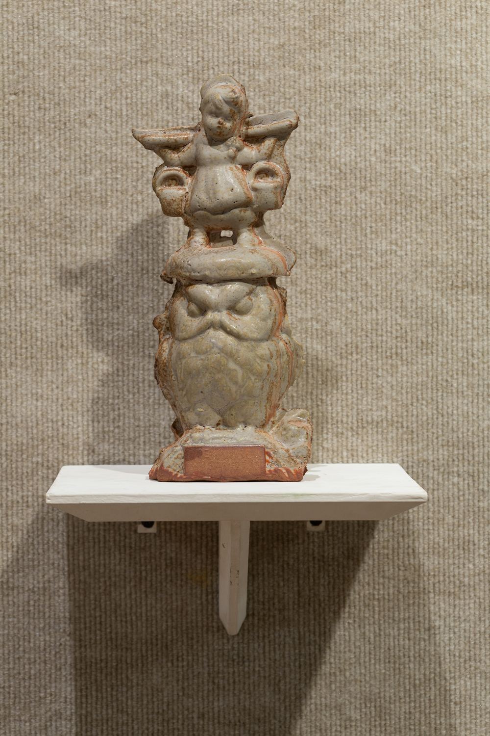 Keaton Wynn ceramics: a stacked, glazed ceramic figure on a wall shelf