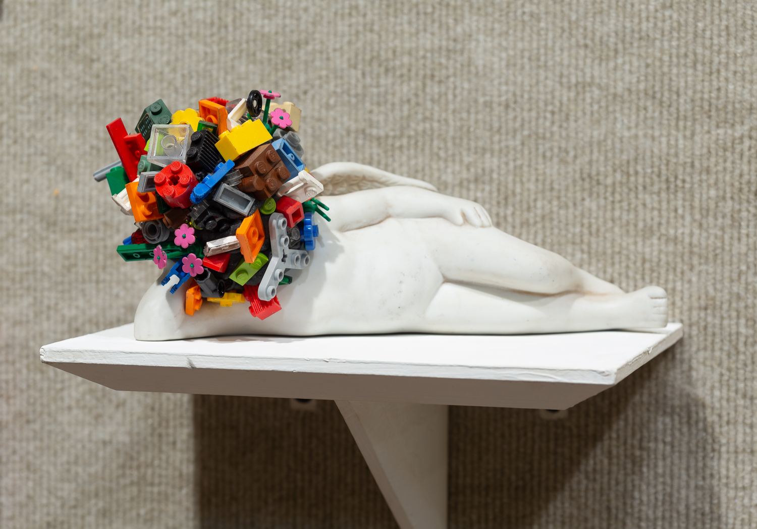 Keaton Wynn ceramics: a reclining white figure strewn with small coloured forms